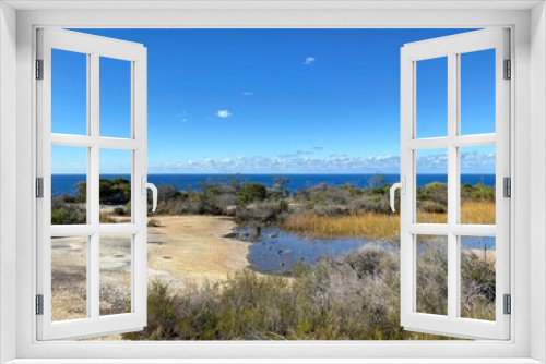 Fototapeta Naklejka Na Ścianę Okno 3D - Dry vegetation and rock formation at the summit. Desert rocky plateau. Views from a mountain-top lookout. Australia, Sydney. Ocean at the horizon.