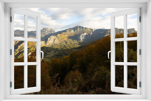 Fototapeta Naklejka Na Ścianę Okno 3D - Landscape of Peaks of Europe national park at sunset with bright sunset sky and autumn forest with colorful yellow and orange leaves