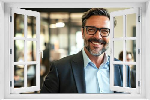 Attractive smiling young confident businessman in formal wear standing in the office