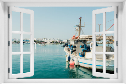 Fototapeta Naklejka Na Ścianę Okno 3D - Fishing boat in the port of Antiparos, Greece with the beachfront in the background.