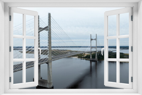 Fototapeta Naklejka Na Ścianę Okno 3D - The Dames Point Bridge in Jacksonville, Florida, captured in daylight with cars driving over and water underneath.