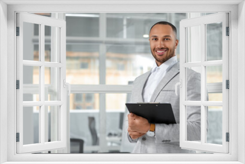 Happy man with clipboard in office, space for text. Lawyer, businessman, accountant or manager