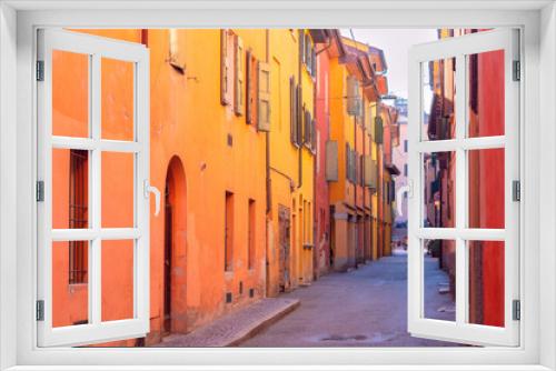 Fototapeta Naklejka Na Ścianę Okno 3D - Bright multi-colored facades of old houses on a narrow street in Bologna.