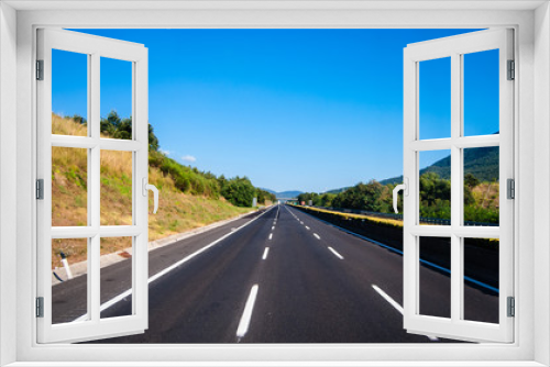 Fototapeta Naklejka Na Ścianę Okno 3D - asphalt road through the green field and clouds on blue sky in s