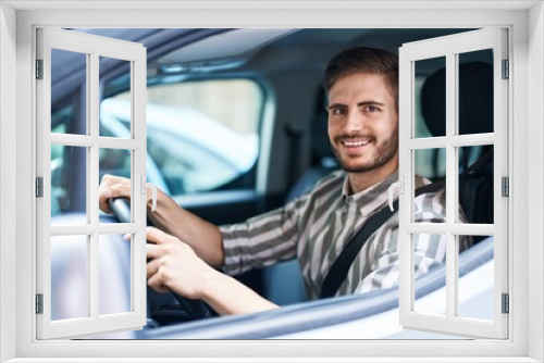 Hispanic man with beard driving car looking positive and happy standing and smiling with a confident smile showing teeth