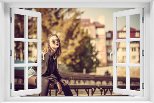 Young pretty girl sitting on bench in park