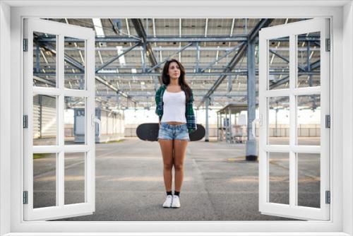 Young girl with skateboard portrait outdoors in a empty parking