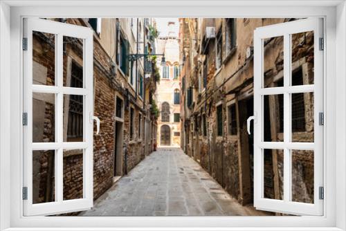 Fototapeta Naklejka Na Ścianę Okno 3D - Looking down the narrow streets or alley of Venice