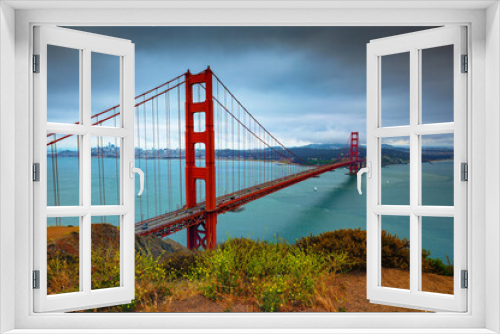 Fototapeta Naklejka Na Ścianę Okno 3D - Golden Gate Bridge on a cloudy day with San Francisco city skyline in the background and flowers in the foreground.