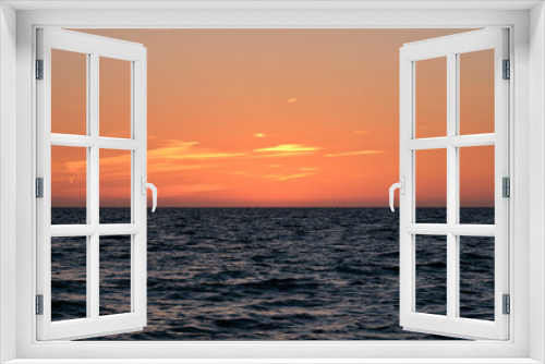 Fototapeta Naklejka Na Ścianę Okno 3D - Dramatic bright red sky at ocean sunset, soft evening clouds over sea dark water