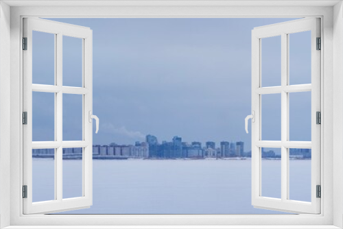 Fototapeta Naklejka Na Ścianę Okno 3D - Winter cityscape: modern city with expressway on the seashore covered with ice