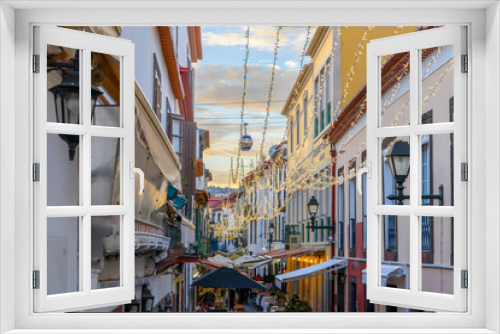 Fototapeta Naklejka Na Ścianę Okno 3D - A cable car gondola to the town of Monte passes over the famous Rua de Santa Maria narrow street of cafes, colorful doors and shops in the historic medieval old town of Funchal, Madeira Portugal.