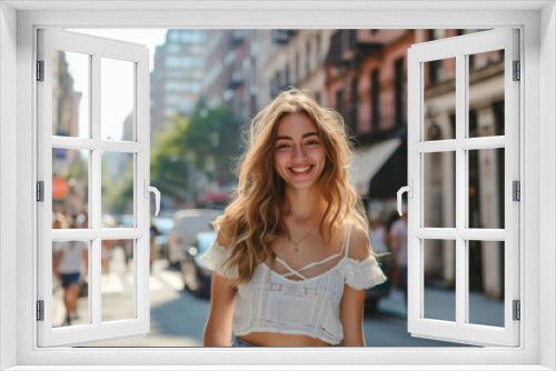 A woman in a white off the shoulder top smiles for the camera