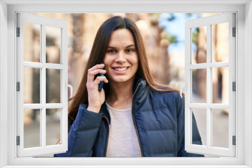 Young beautiful hispanic woman smiling confident talking on the smartphone at street