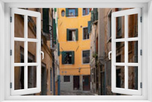 Fototapeta Naklejka Na Ścianę Okno 3D - Typical narrow street with historical houses in Venice. Narrow pedestrian streets of Venice between the channels. Some quiet places almost without people.