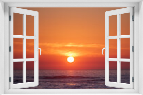 Fototapeta Naklejka Na Ścianę Okno 3D - A bright sunset on the vibrant orange sky over the Atlantic Ocean. Vertical photo with empty space for text