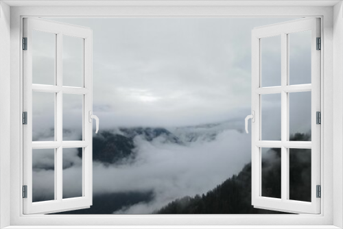 Fototapeta Naklejka Na Ścianę Okno 3D - a view looking across the clouds over mountains on a cloudy day