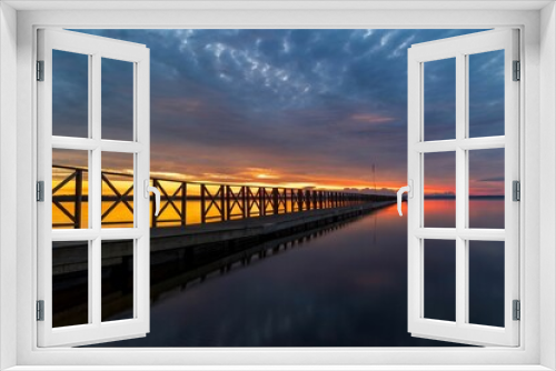 Fototapeta Naklejka Na Ścianę Okno 3D - Scenic view of a bridge arched over a body of water at sunset.