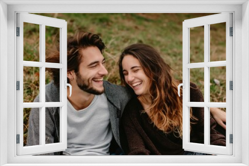 couple sitting on a grass in summer laughing