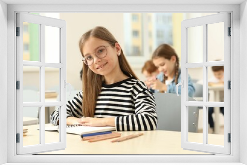 Portrait of smiling little girl studying in classroom at school