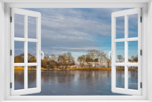 Fototapeta Naklejka Na Ścianę Okno 3D - Winter landscape by frozen lake with trees on a snowy shore