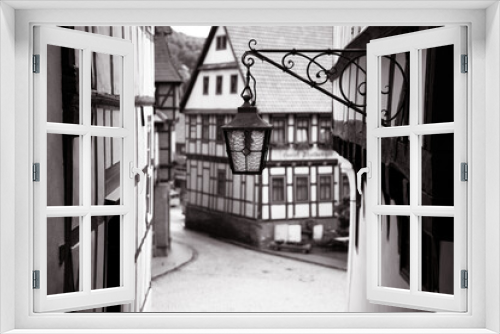 Fototapeta Naklejka Na Ścianę Okno 3D - A picturesque half-timbered house next to an old street lantern gives the village a charming flair of times gone by.