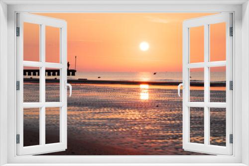 Fototapeta Naklejka Na Ścianę Okno 3D - Sunrise at the Beach in Italy. Orange sky and Fisherman on Pier in the Background	
