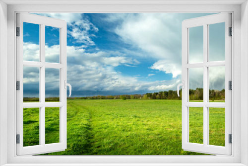 Fototapeta Naklejka Na Ścianę Okno 3D - Clouds over a green meadow, May day