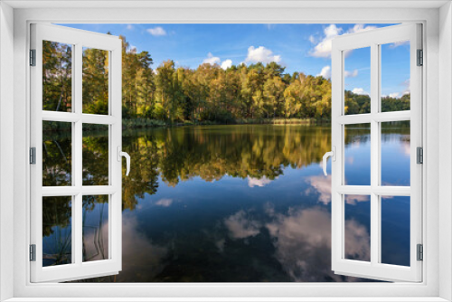 Fototapeta Naklejka Na Ścianę Okno 3D - Natural landscape of the lake, high definition, the movement of waves against the background of the autumn forest. The reflection of clouds on the ripples of water. Germany.