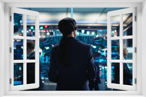 Female Investment Banker Wearing Headphones and Using a Tablet Computer with Financial Market Analytics Data. Team Leader Monitoring Daily Operations, Working of Behalf of Corporate Business Partners