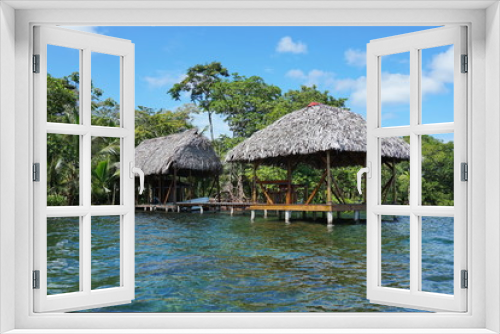 Fototapeta Naklejka Na Ścianę Okno 3D - Thatched tropical hut and boathouse over the sea