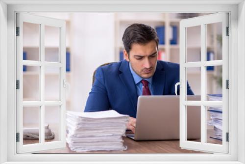 Young male employee and too much work in the office