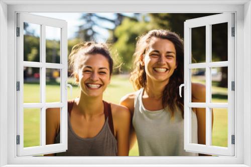 Two women smiling and embracing in natural sunlight.