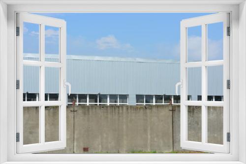 Fototapeta Naklejka Na Ścianę Okno 3D - Warehouse building with concrete walls and white metal-plastic windows.