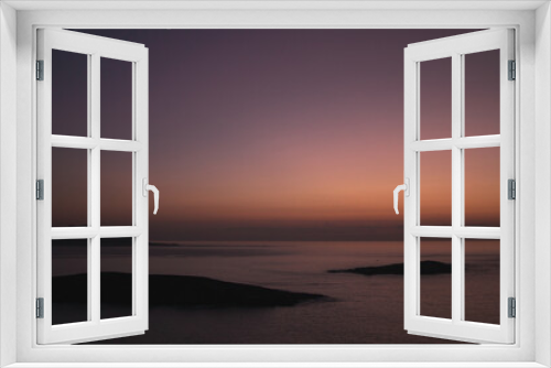 Fototapeta Naklejka Na Ścianę Okno 3D - Sunset view from Monteferro's Rosa dos Ventos viewpoint, showcasing a serene horizon over tranquil seas. Silhouettes of Estelas Islands and distant Cabo Silleiro under a vibrant orange and purple sky.