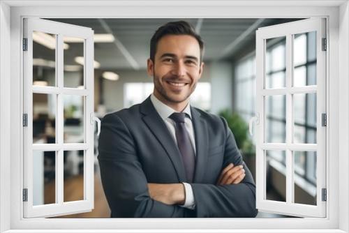 Portrait of happy businessman with arms crossed standing in office