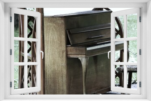 Fototapeta Naklejka Na Ścianę Okno 3D - Stare pianino stoi w parki. Elegancki fortepiany postawiony na świeżym powietrzu dla przechodniów. Zabytkowy instrument, krzesło i osłona z drewna.