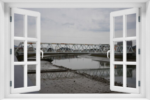 Fototapeta Naklejka Na Ścianę Okno 3D - 
low tide
blue bridge
cloudy sky
rusty bridge