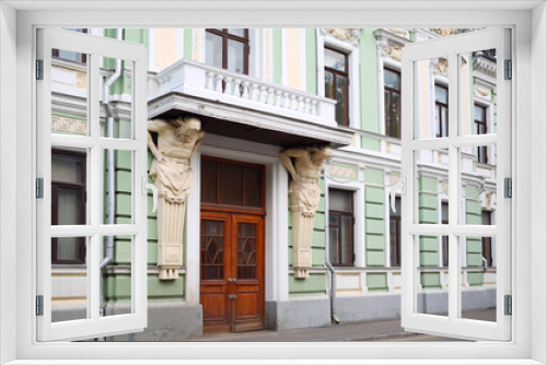 Fototapeta Naklejka Na Ścianę Okno 3D - Old building with two atlants with moldings around windows in Moscow, Russia