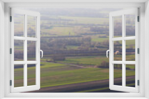 Fototapeta Naklejka Na Ścianę Okno 3D - A scenic view over the foggy landscape. An aerial lookout of the fields in the misty valley.