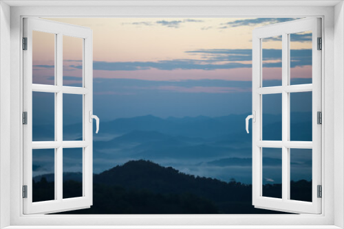 Fototapeta Naklejka Na Ścianę Okno 3D - Background image of a morning landscape on a mountaintop with mountains and a sea of ​​mist before the sun rises. There is space for text.