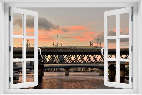Fototapeta Naklejka Na Ścianę Okno 3D - 夕日に染まる京浜運河を横切る鉄橋を渡る新幹線