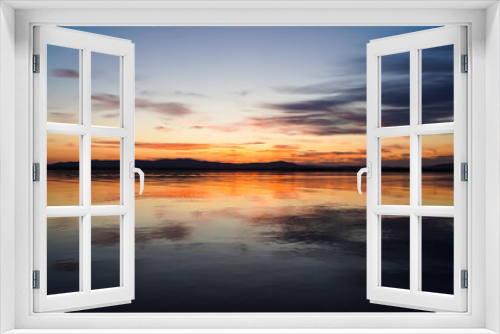 Fototapeta Naklejka Na Ścianę Okno 3D - Beautiful sunset overlooking a quiet lake and mountains. The golden hour, a mirror image on the water. Beauty is in nature.