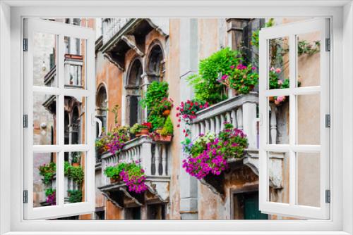 Fototapeta Naklejka Na Ścianę Okno 3D - Balconies of residential house in Venice decorated with flowers