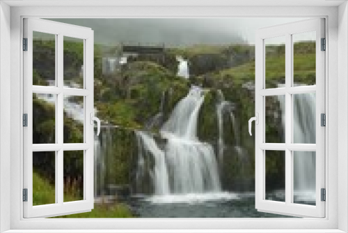 Fototapeta Naklejka Na Ścianę Okno 3D - Vertical shot of flowing waterfalls on a cliff in Iceland