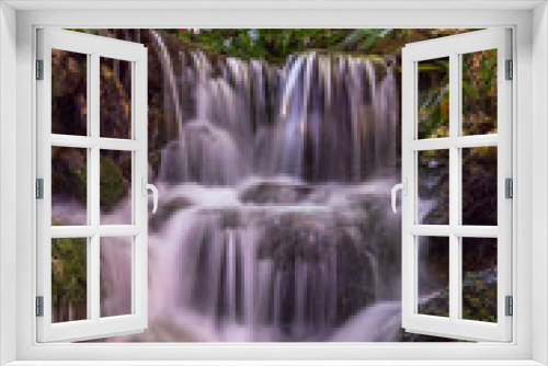 Fototapeta Naklejka Na Ścianę Okno 3D - A scenic view of a calmly flowing waterfall.