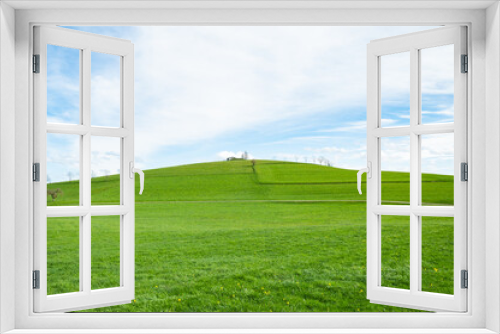 Fototapeta Naklejka Na Ścianę Okno 3D - Landscape view of green grass on slope with blue sky