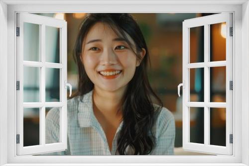 An aesthetically pleasing portrait of a young woman sitting in a modern café, with intentional focus on the ambient interior lighting