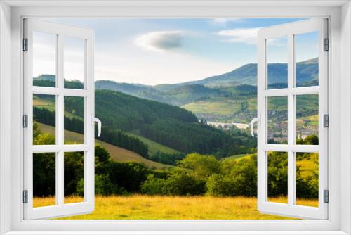 Fototapeta Naklejka Na Ścianę Okno 3D - carpathian countryside scenery of ukraine on a sunny morning in summer. forest on the hills and town in the valley. borzhava mountain range in the far distance beneath bright blue sky