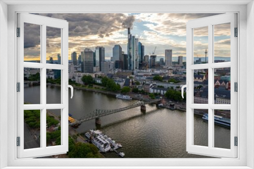 Fototapeta Naklejka Na Ścianę Okno 3D - Aerial view of Main River with a modern city at the shore with fluffy clouds in the sky